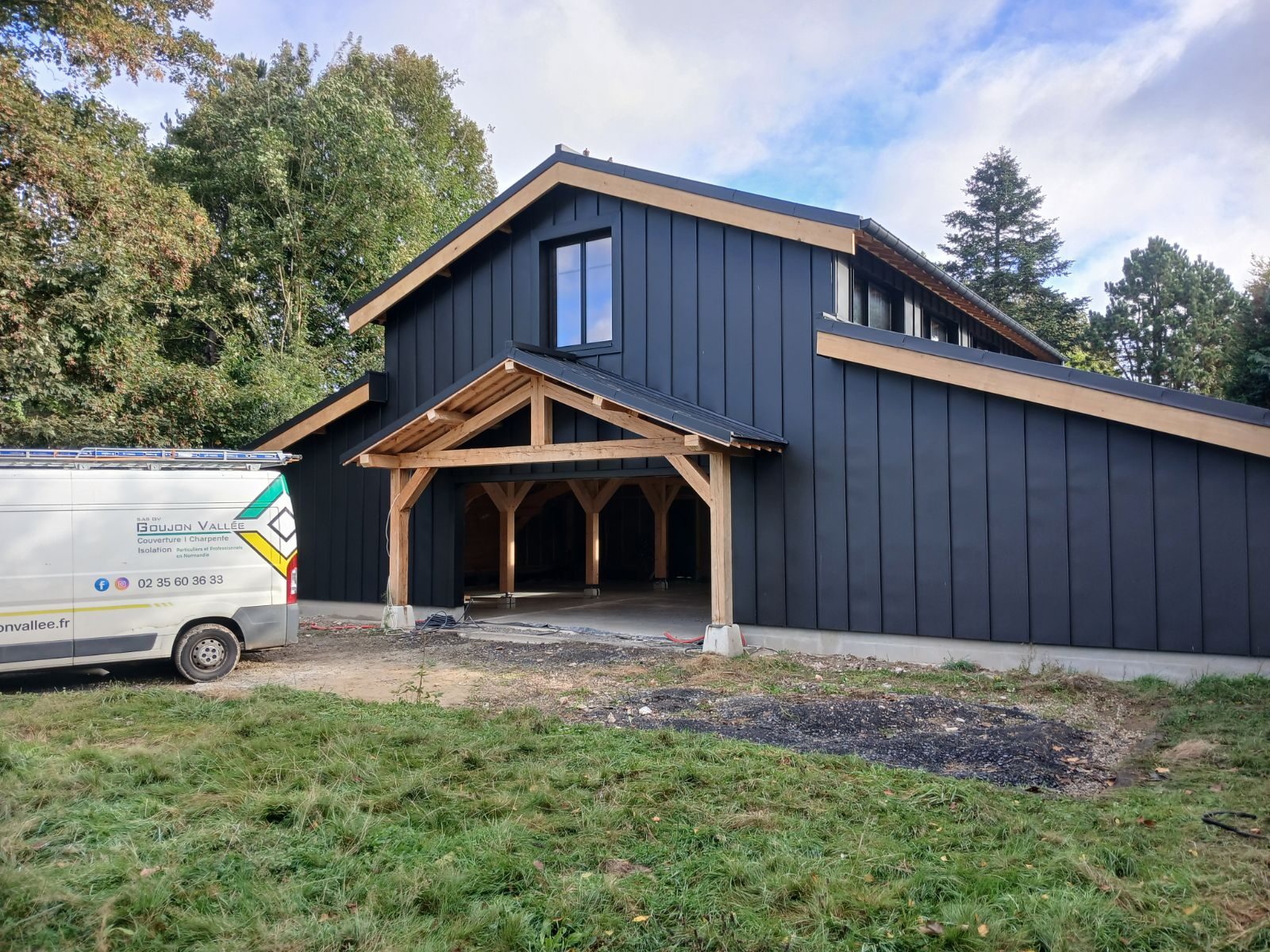 Bâtiment en bardage noir et charpente bois réalisé par Goujon Vallée en Normandie